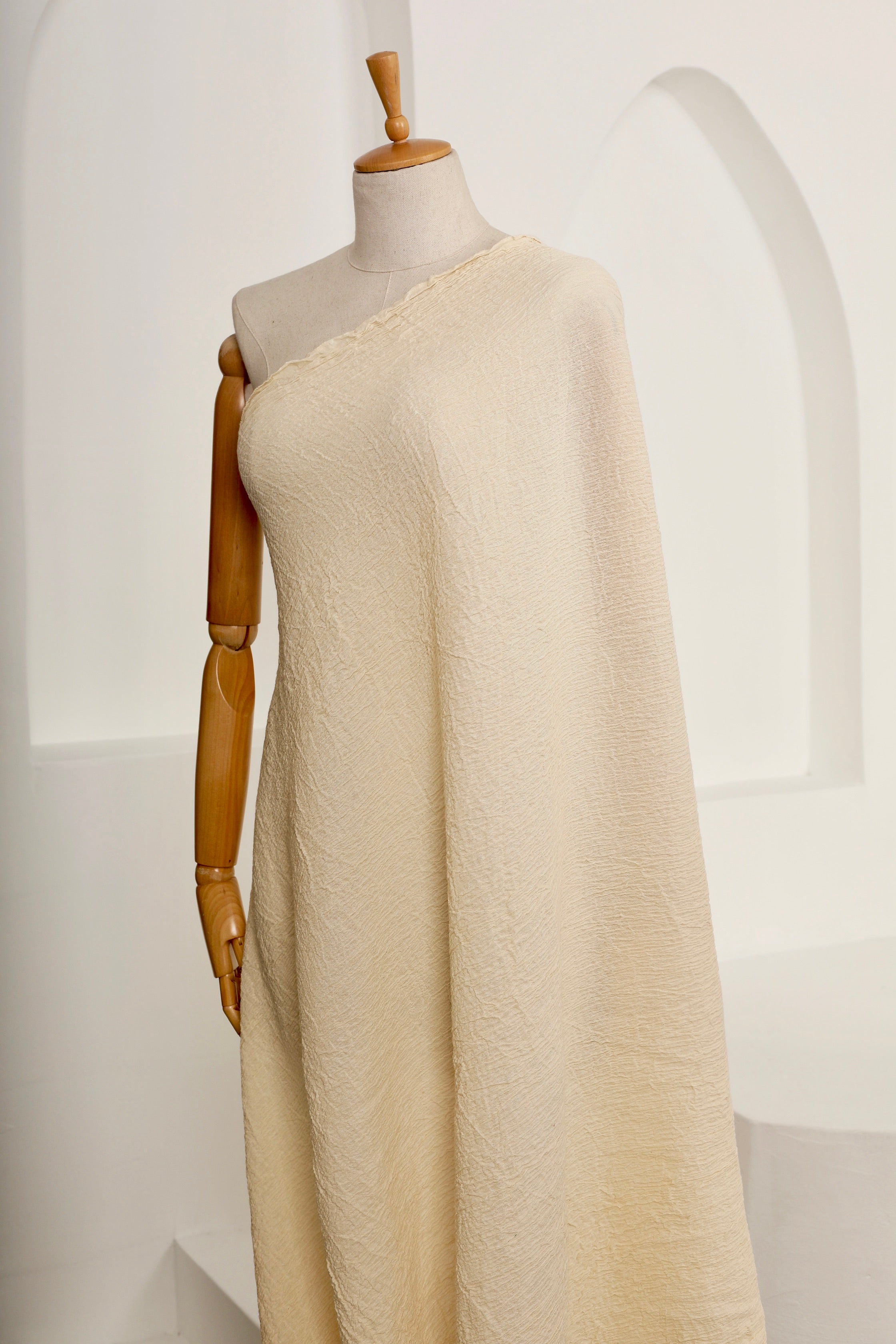 Tissu en coton froissé extensible neutre, surface texturée, coton tissé à la main blanc cassé, coton beige biologique semi-transparent et non blanchi.