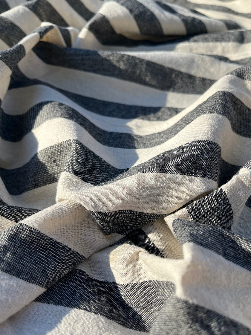 Tissu naturel en gaze de coton à rayures noires.