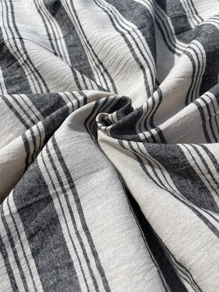 Tissu naturel en gaze de coton à rayures noires.