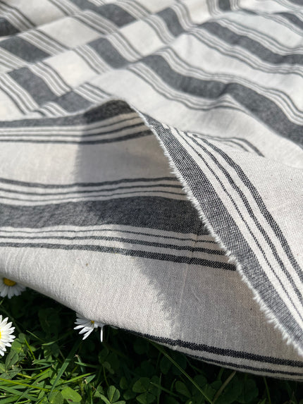 Tissu naturel en gaze de coton à rayures noires.