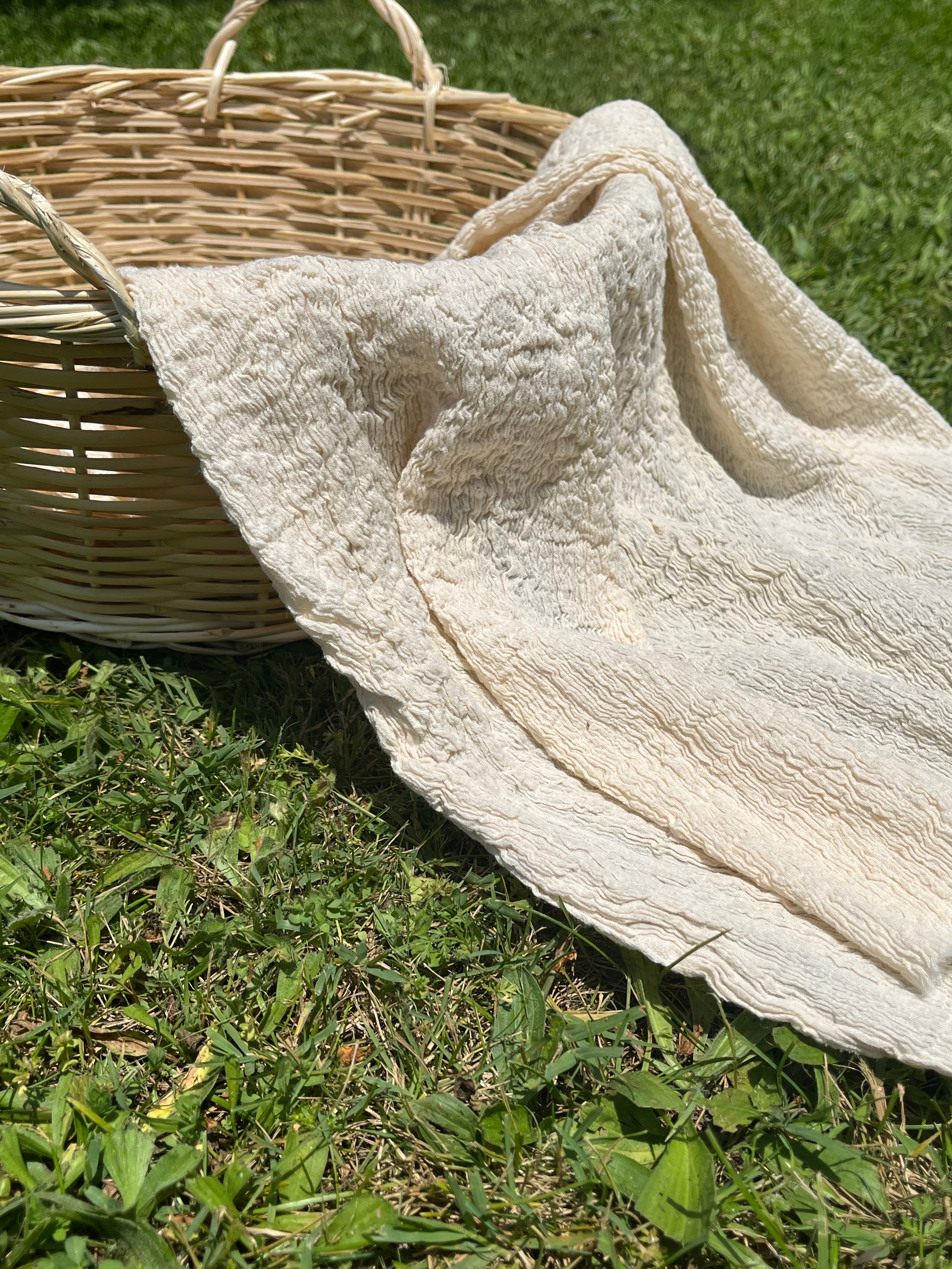 Tissu en coton froissé extensible neutre, surface texturée, coton tissé à la main blanc cassé, coton beige biologique semi-transparent et non blanchi.