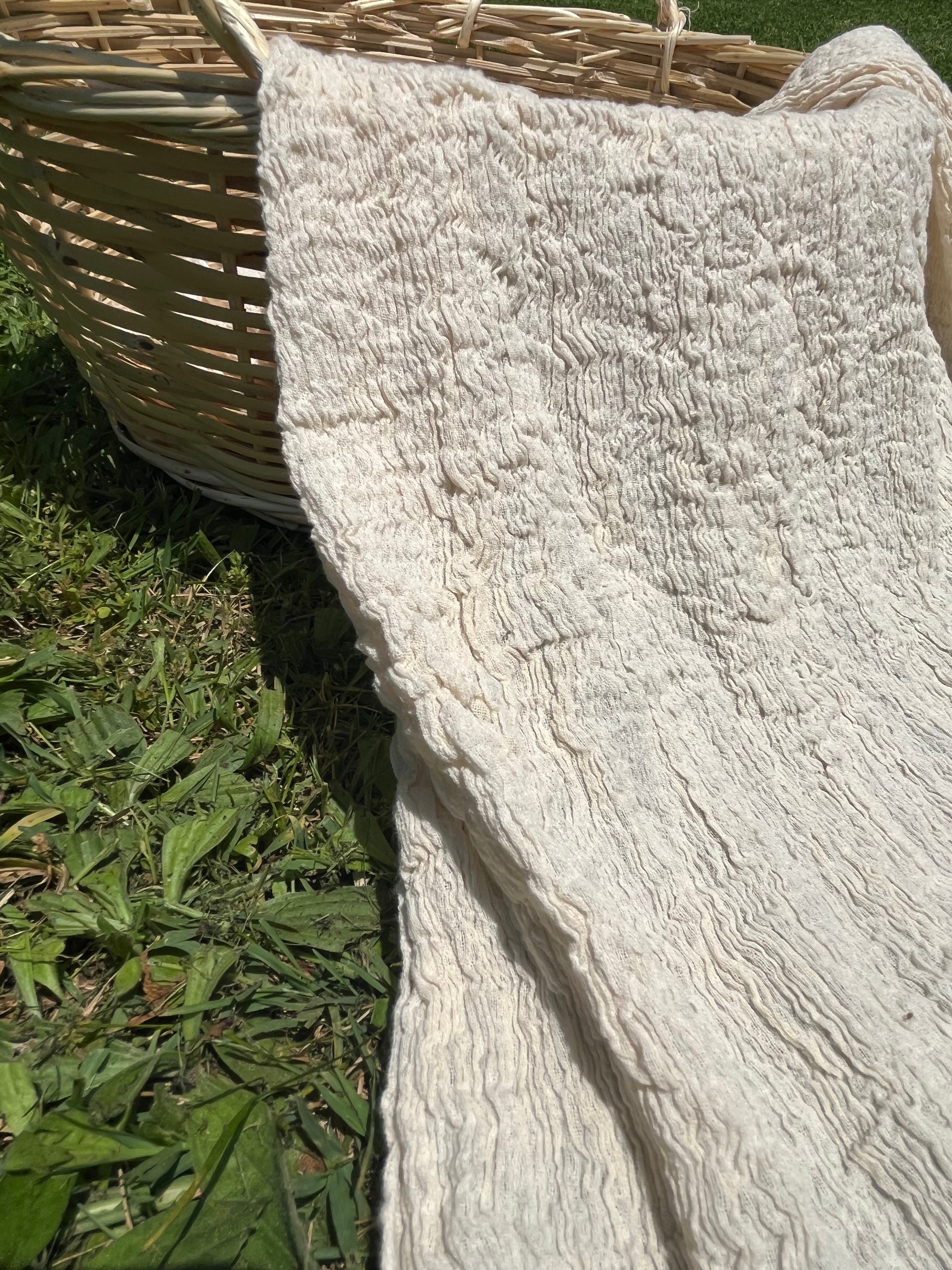Tissu en coton froissé extensible neutre, surface texturée, coton tissé à la main blanc cassé, coton beige biologique semi-transparent et non blanchi.