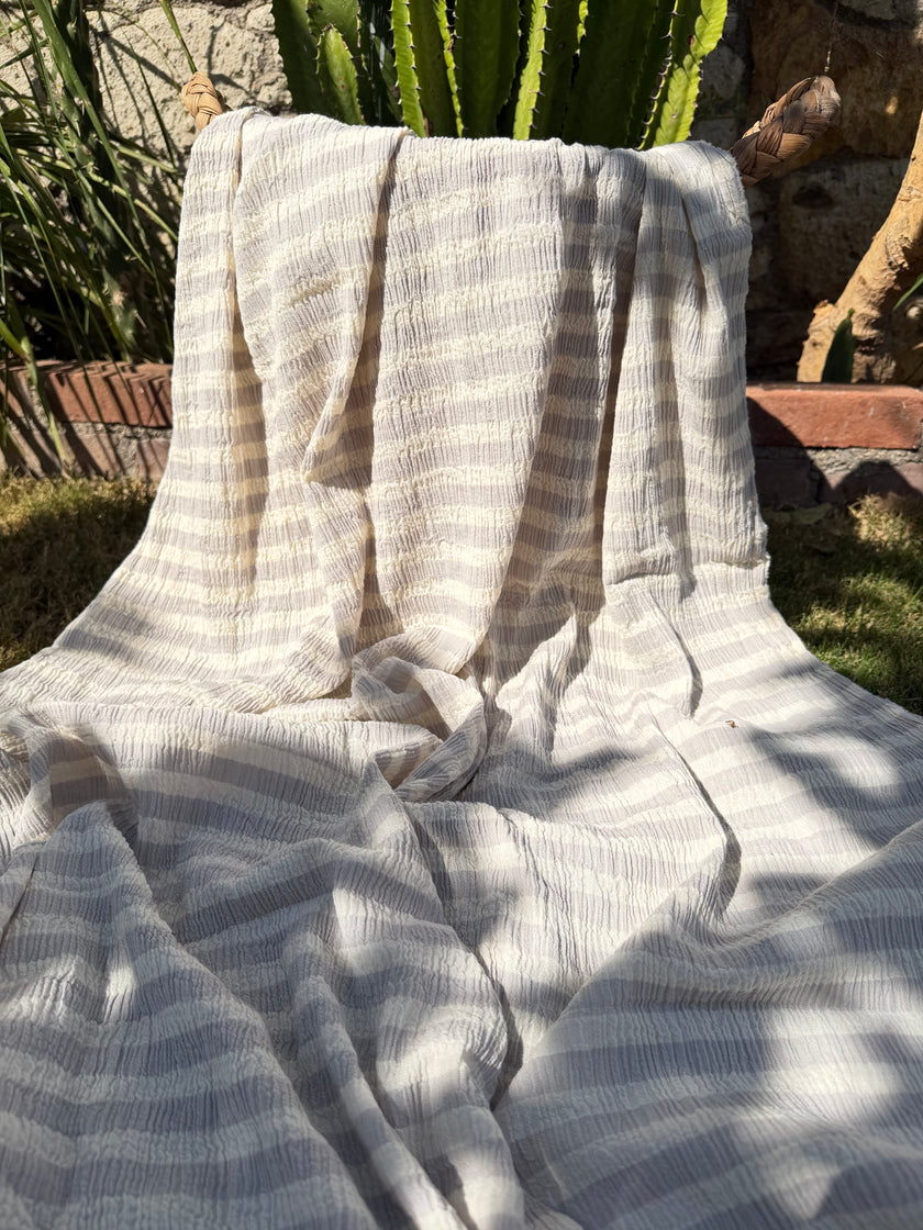 Tissu en coton froissé extensible neutre, surface texturée, coton tissé à la main blanc cassé, coton beige biologique semi-transparent et non blanchi.