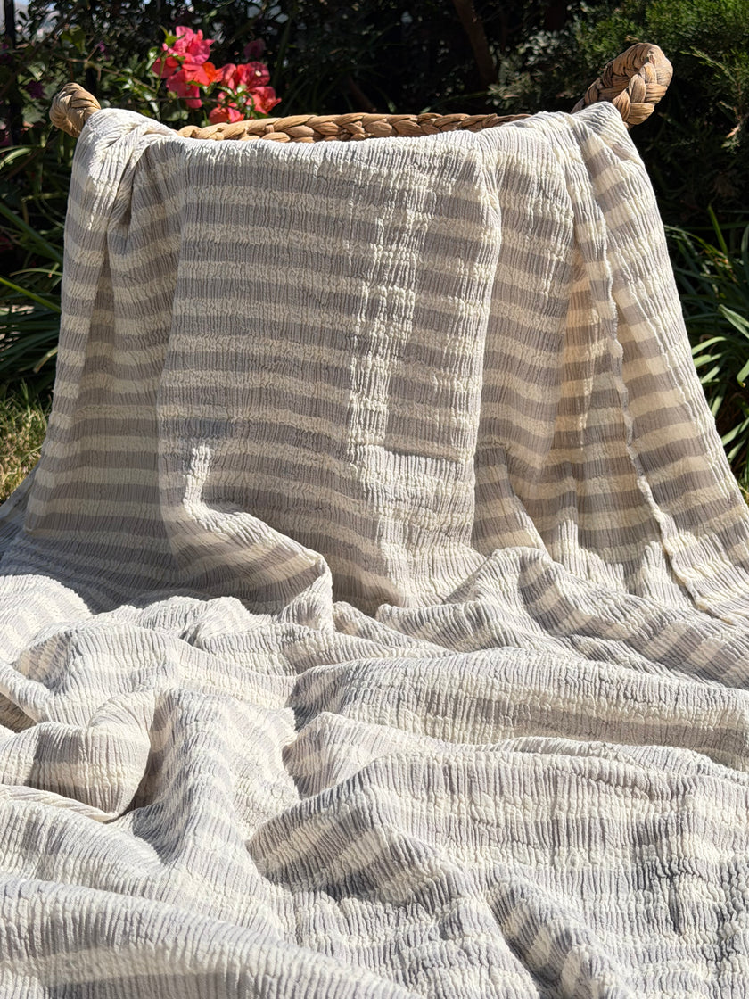Tissu en coton froissé extensible neutre, surface texturée, coton tissé à la main blanc cassé, coton beige biologique semi-transparent et non blanchi.