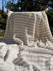 Tissu en coton froissé extensible neutre, surface texturée, coton tissé à la main blanc cassé, coton beige biologique semi-transparent et non blanchi.