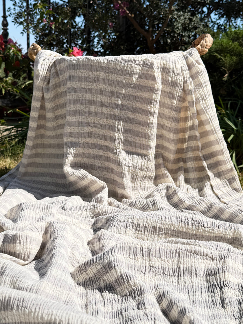 Tissu en coton froissé extensible neutre, surface texturée, coton tissé à la main blanc cassé, coton beige biologique semi-transparent et non blanchi.