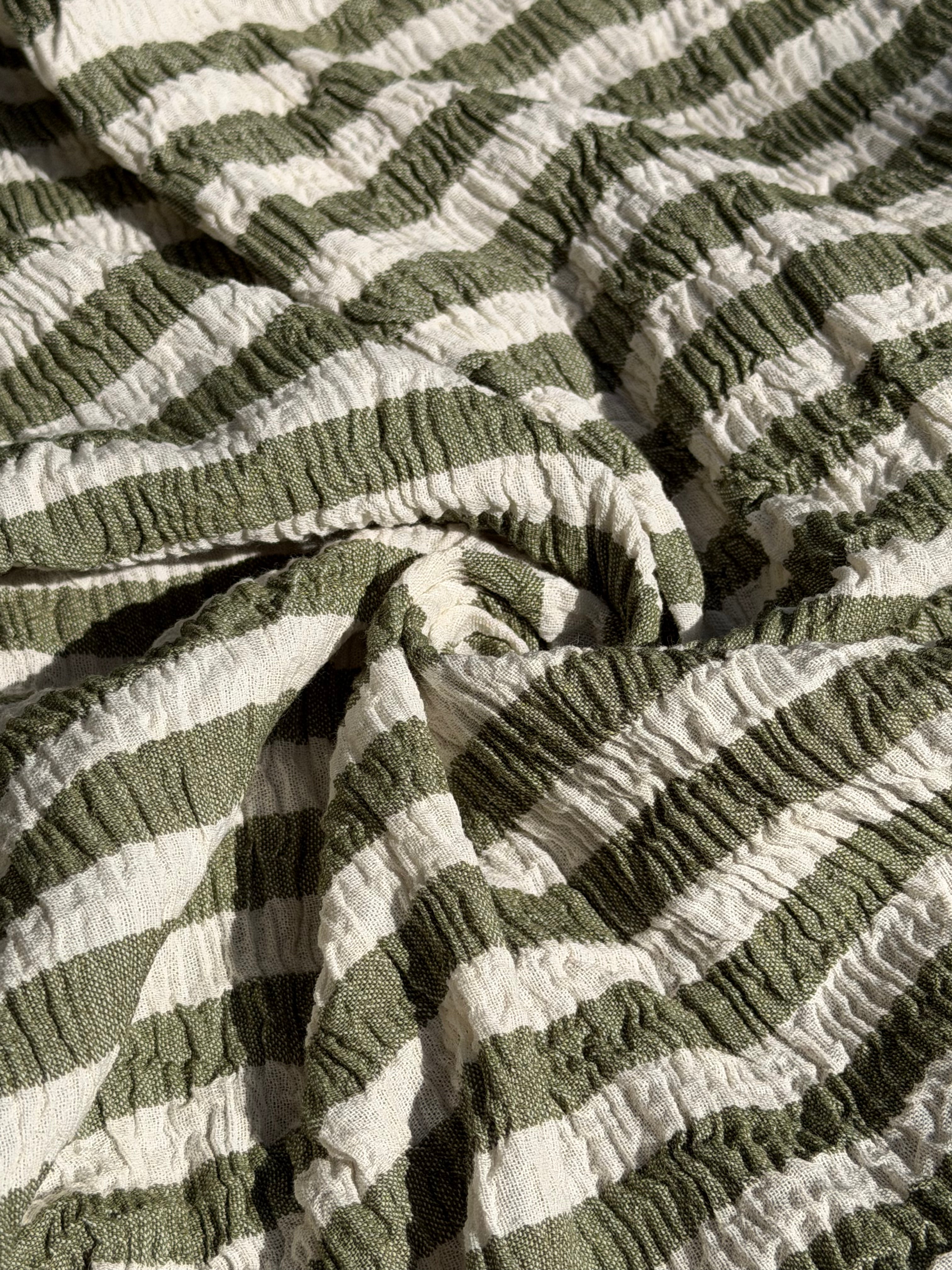 Tissu en coton froissé extensible neutre, surface texturée, coton tissé à la main blanc cassé, coton beige biologique semi-transparent et non blanchi.