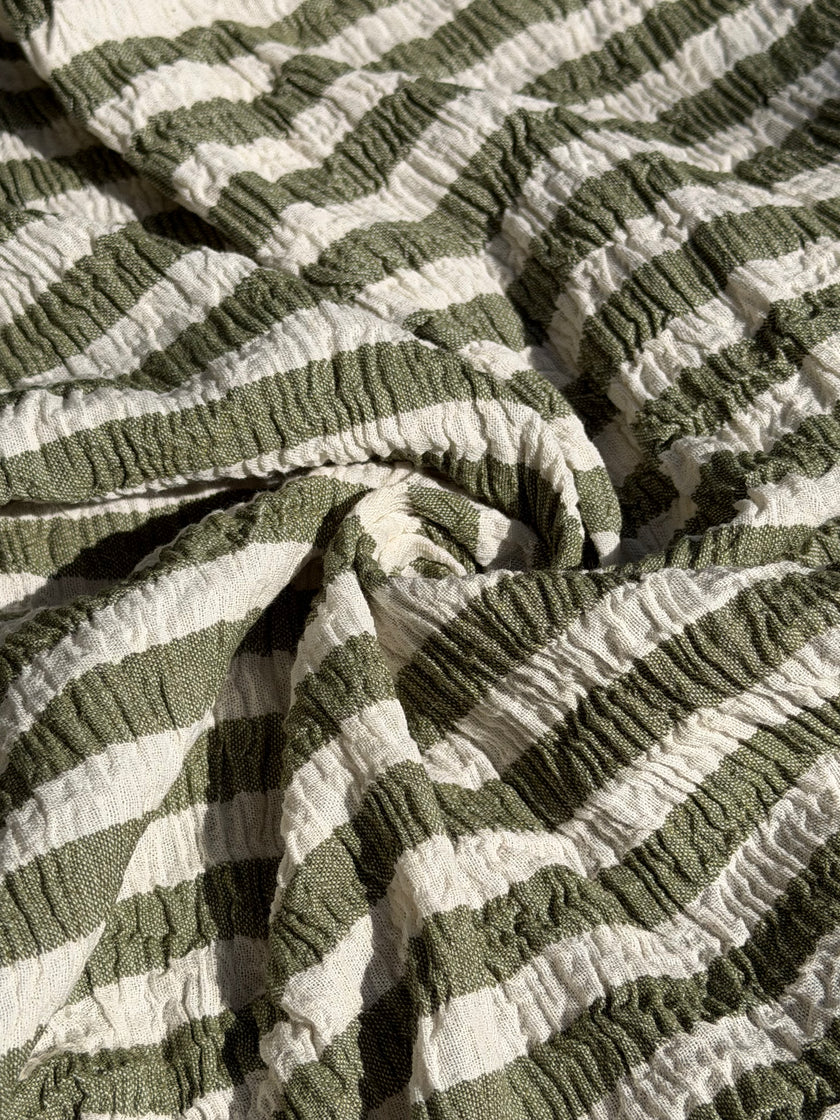 Tissu en coton froissé extensible neutre, surface texturée, coton tissé à la main blanc cassé, coton beige biologique semi-transparent et non blanchi.