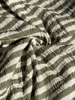 Tissu en coton froissé extensible neutre, surface texturée, coton tissé à la main blanc cassé, coton beige biologique semi-transparent et non blanchi.
