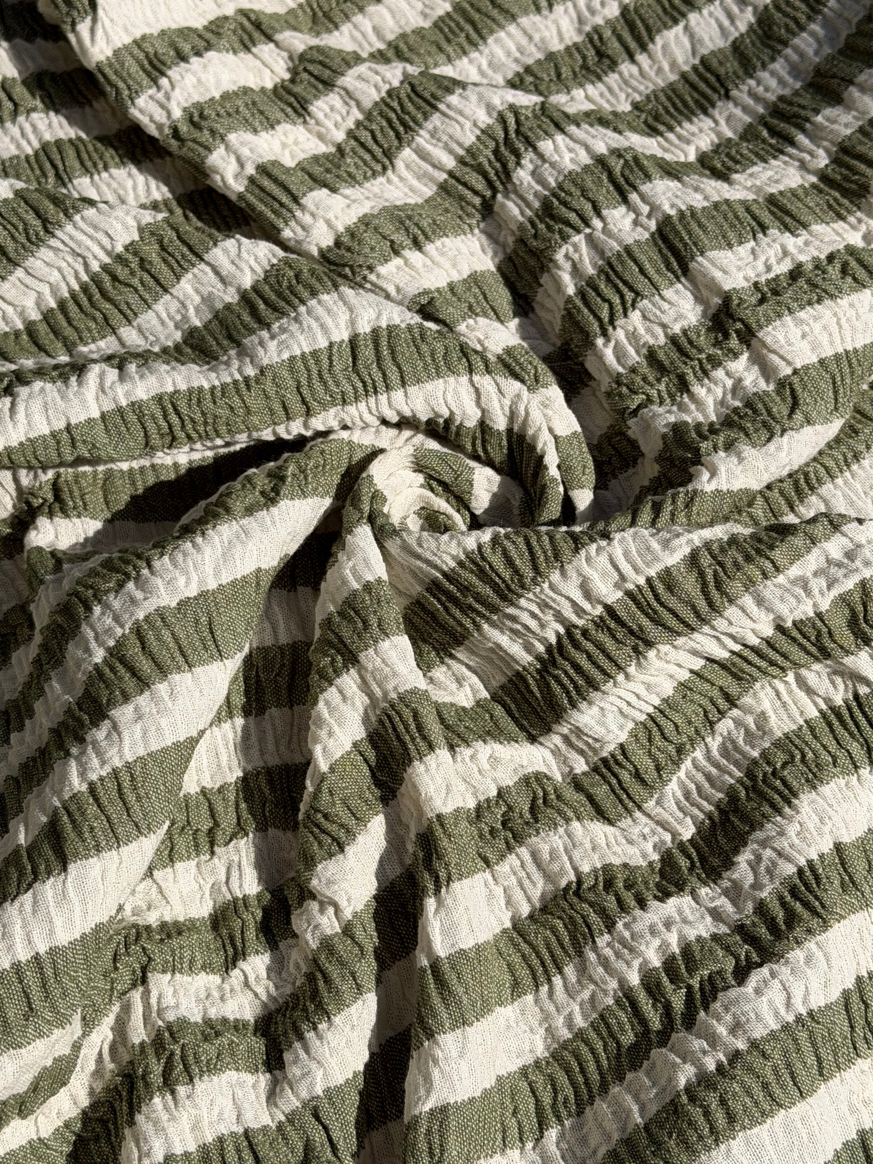 Tissu en coton froissé extensible neutre, surface texturée, coton tissé à la main blanc cassé, coton beige biologique semi-transparent et non blanchi.