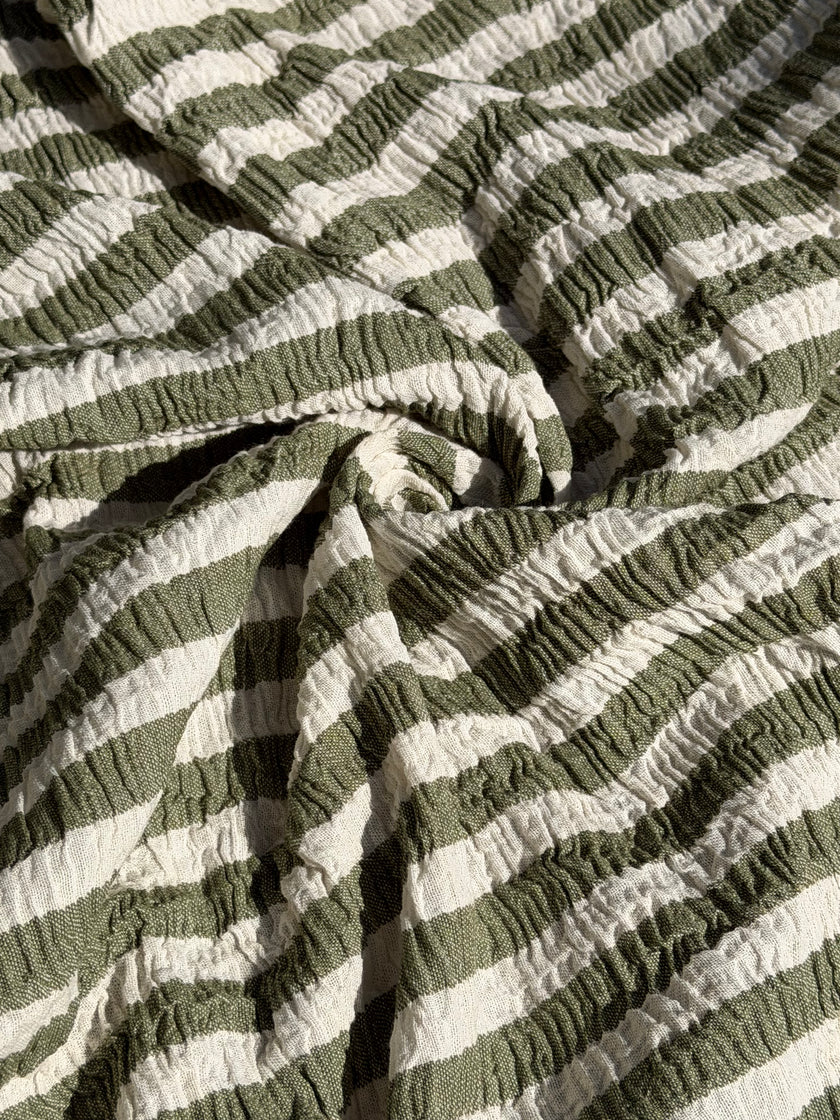 Tissu en coton froissé extensible neutre, surface texturée, coton tissé à la main blanc cassé, coton beige biologique semi-transparent et non blanchi.