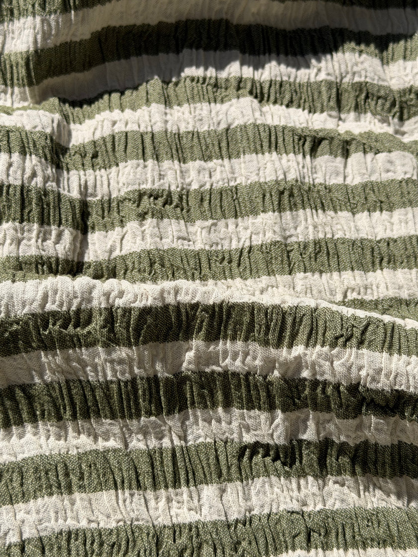 Tissu en coton froissé extensible neutre, surface texturée, coton tissé à la main blanc cassé, coton beige biologique semi-transparent et non blanchi.