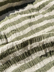 Tissu en coton froissé extensible neutre, surface texturée, coton tissé à la main blanc cassé, coton beige biologique semi-transparent et non blanchi.