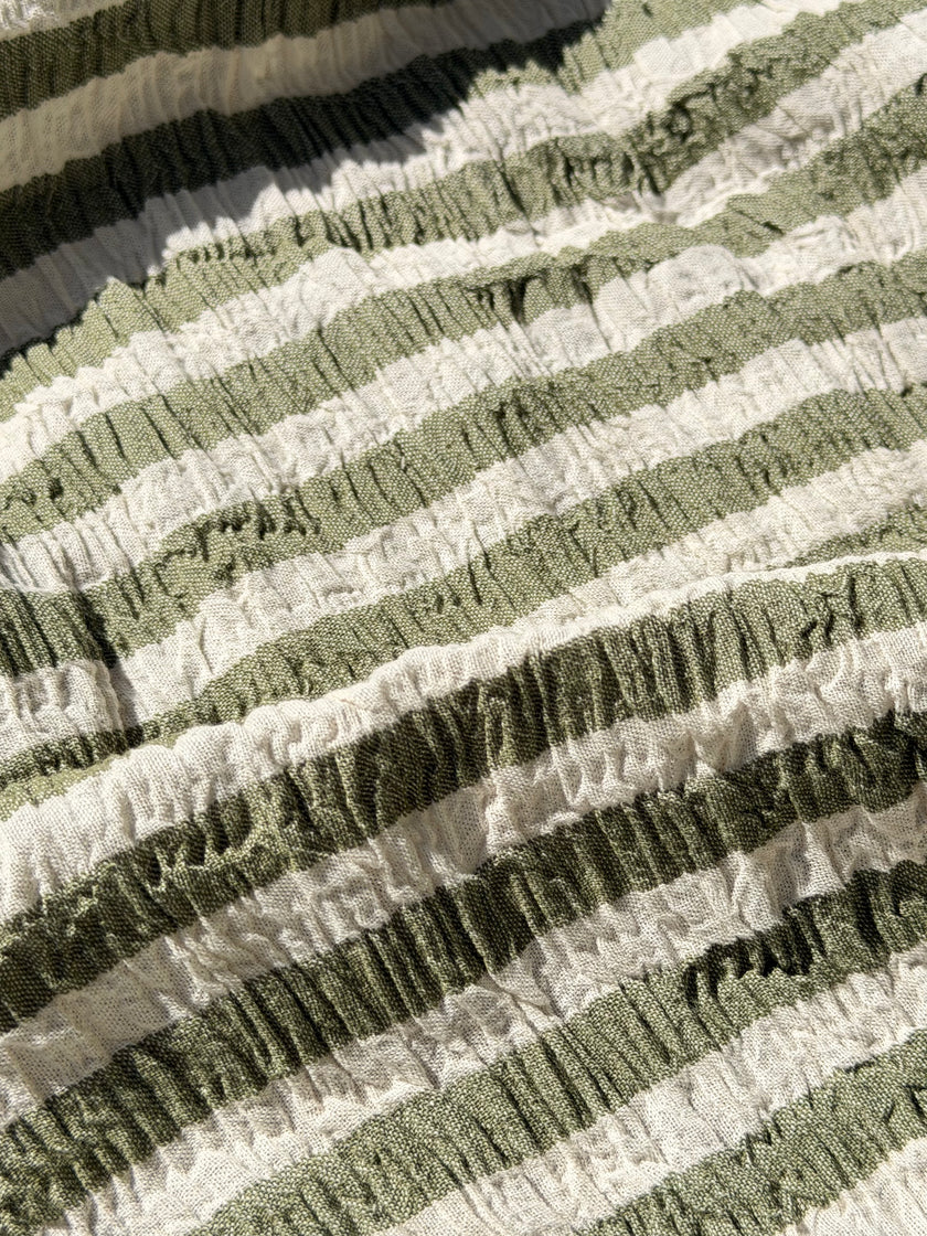 Tissu en coton froissé extensible neutre, surface texturée, coton tissé à la main blanc cassé, coton beige biologique semi-transparent et non blanchi.