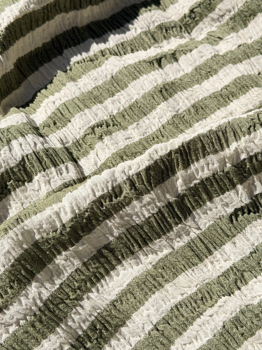 Tissu en coton froissé extensible neutre, surface texturée, coton tissé à la main blanc cassé, coton beige biologique semi-transparent et non blanchi.