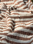 Tissu en coton froissé extensible neutre, surface texturée, coton tissé à la main blanc cassé, coton beige biologique semi-transparent et non blanchi.