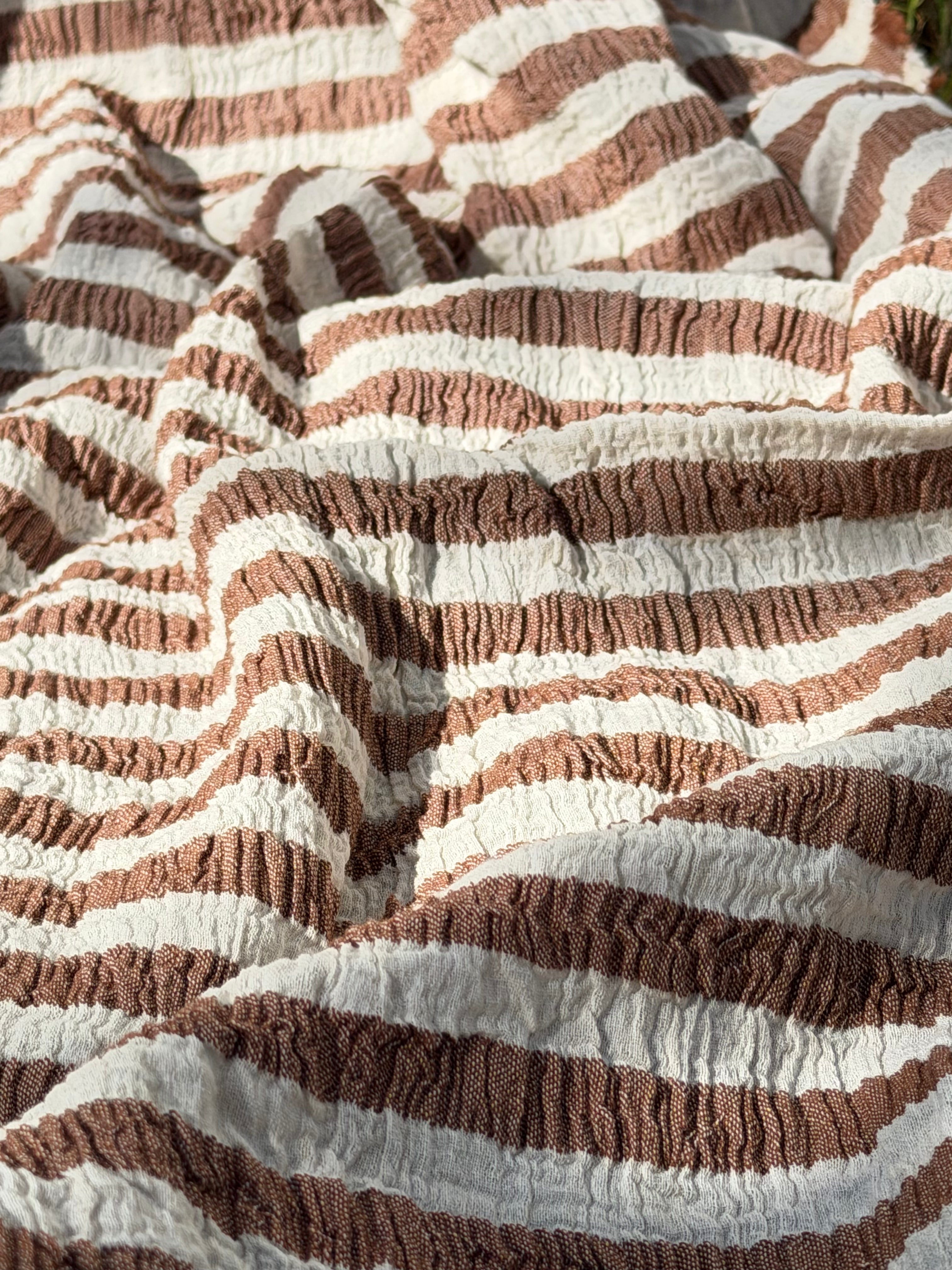 Tissu en coton froissé extensible neutre, surface texturée, coton tissé à la main blanc cassé, coton beige biologique semi-transparent et non blanchi.