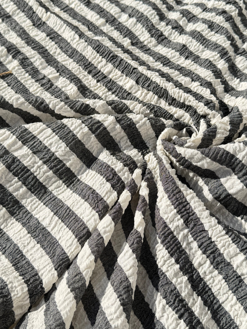 Tissu en coton froissé extensible neutre, surface texturée, coton tissé à la main blanc cassé, coton beige biologique semi-transparent et non blanchi.