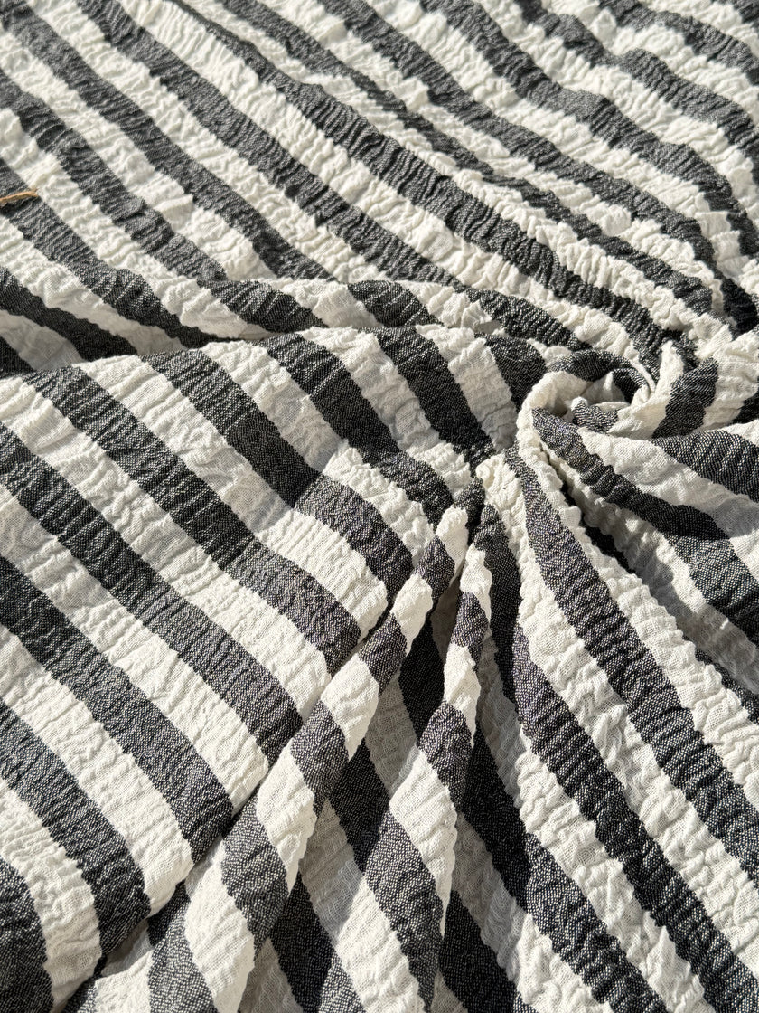 Tissu en coton froissé extensible neutre, surface texturée, coton tissé à la main blanc cassé, coton beige biologique semi-transparent et non blanchi.