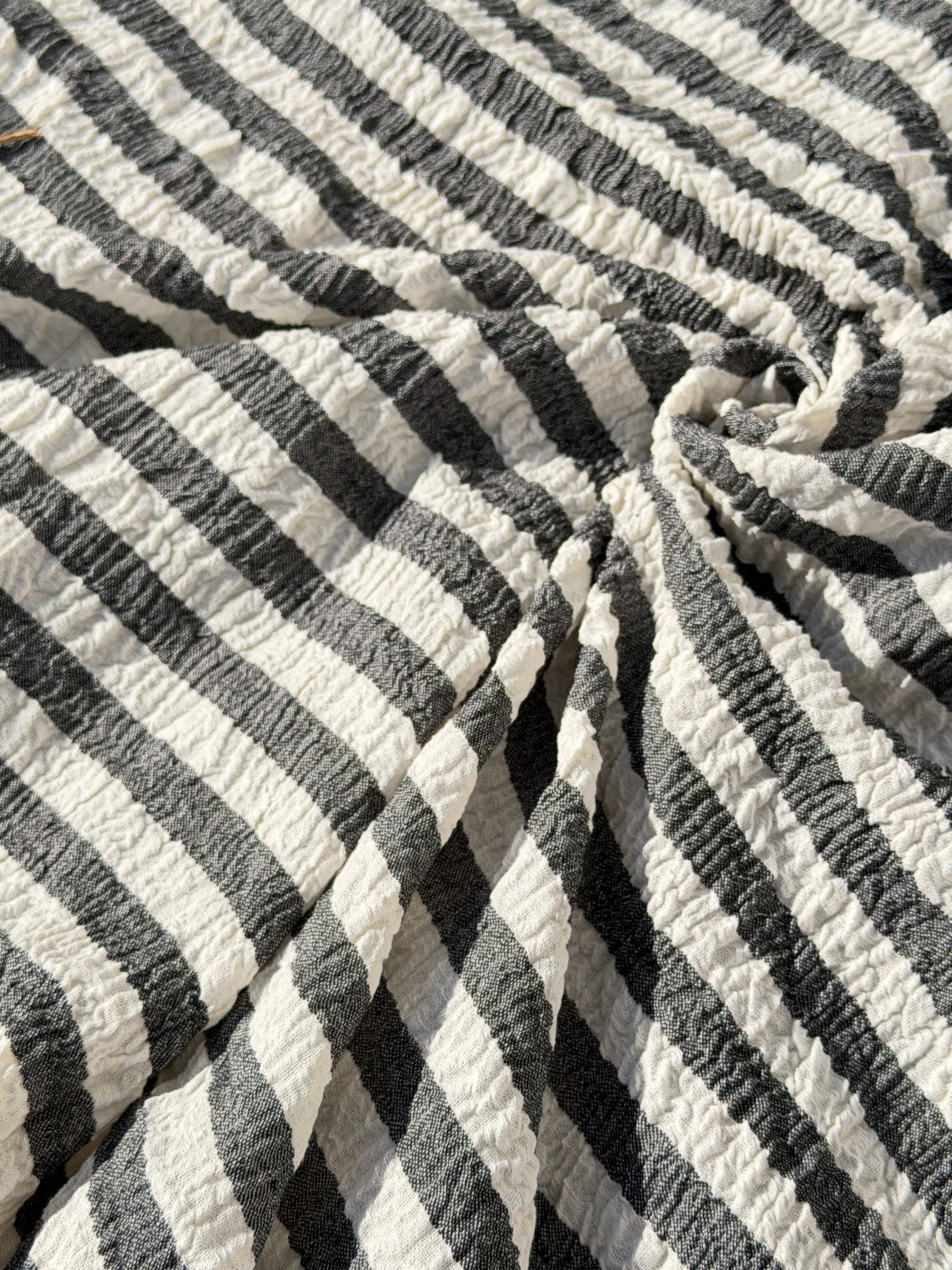 Tissu en coton froissé extensible neutre, surface texturée, coton tissé à la main blanc cassé, coton beige biologique semi-transparent et non blanchi.