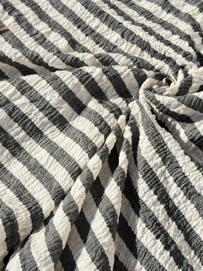 Tissu en coton froissé extensible neutre, surface texturée, coton tissé à la main blanc cassé, coton beige biologique semi-transparent et non blanchi.