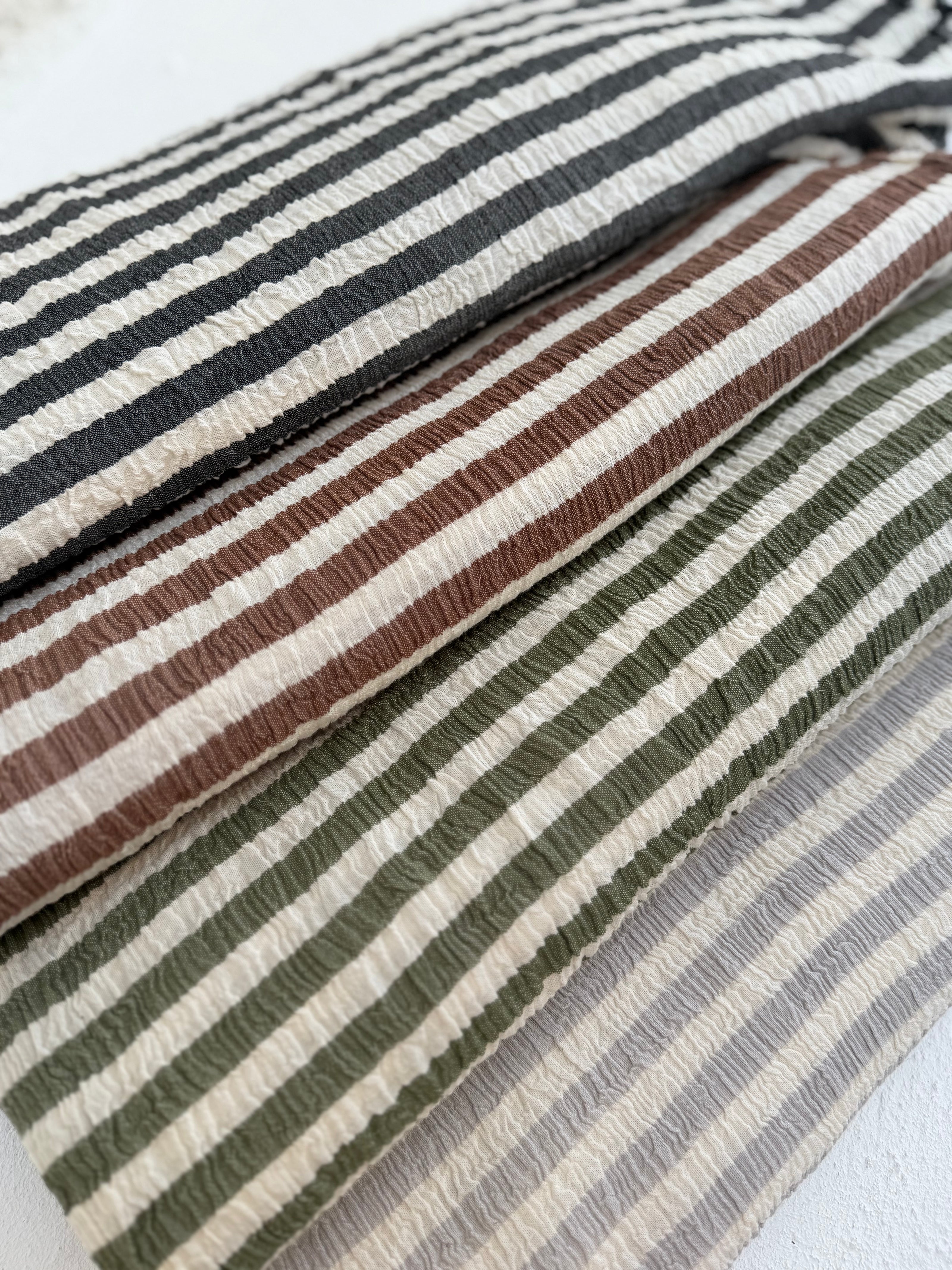 Tissu en coton froissé extensible neutre, surface texturée, coton tissé à la main blanc cassé, coton beige biologique semi-transparent et non blanchi.