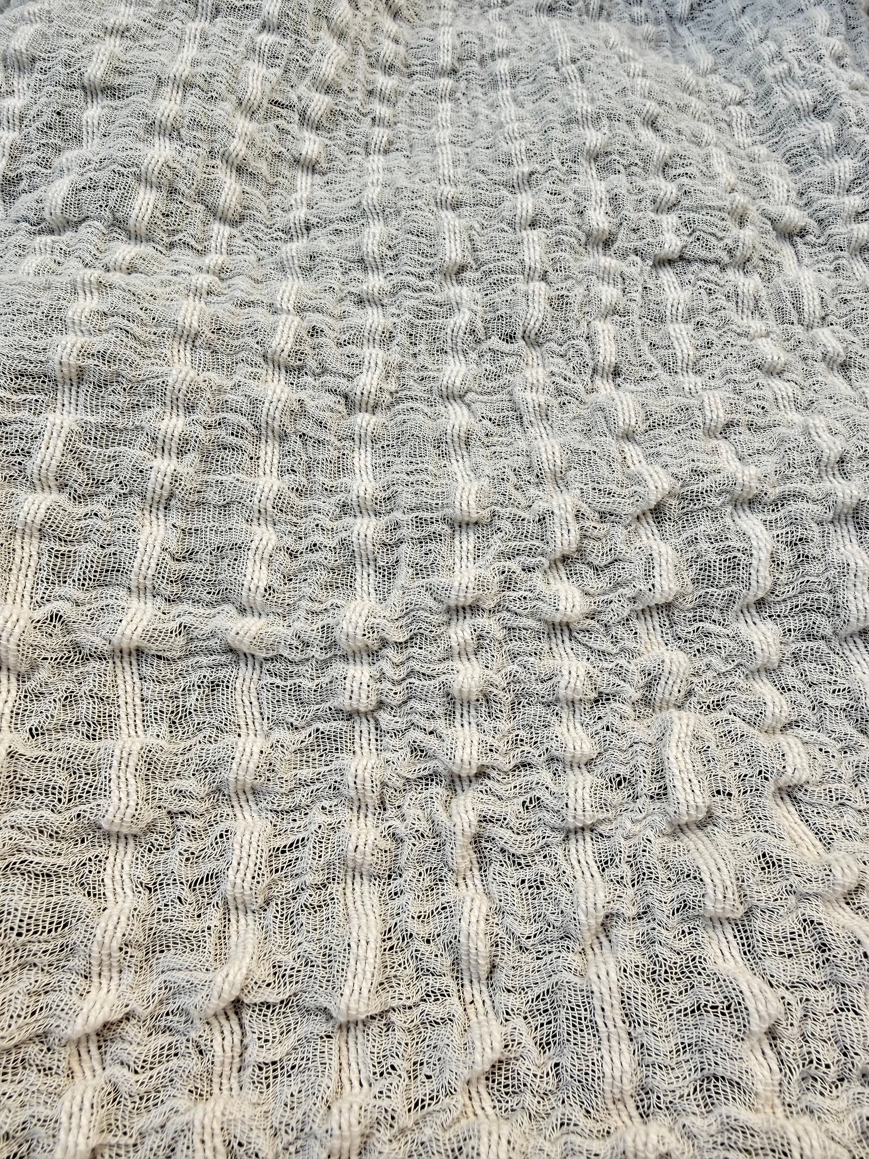 Tissu en coton froissé extensible neutre, surface texturée, coton tissé à la main blanc cassé, coton beige biologique semi-transparent et non blanchi.