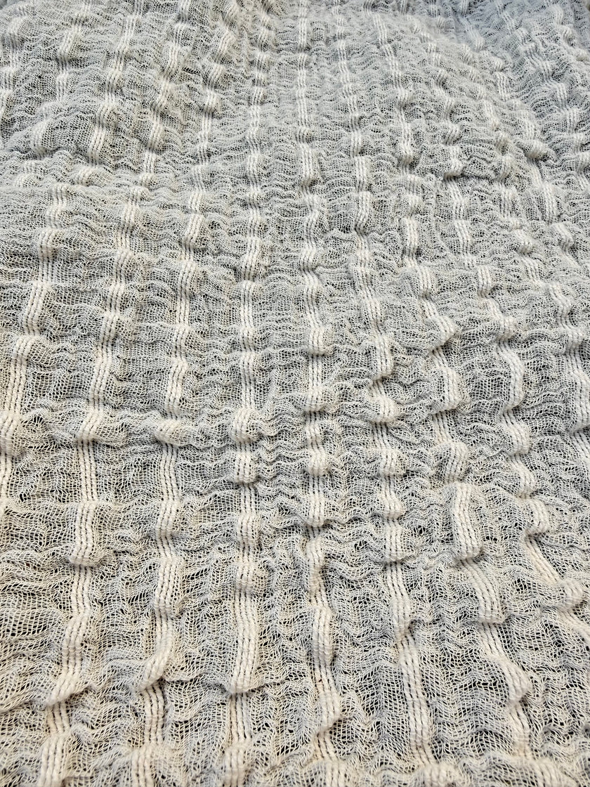 Tissu en coton froissé extensible neutre, surface texturée, coton tissé à la main blanc cassé, coton beige biologique semi-transparent et non blanchi.