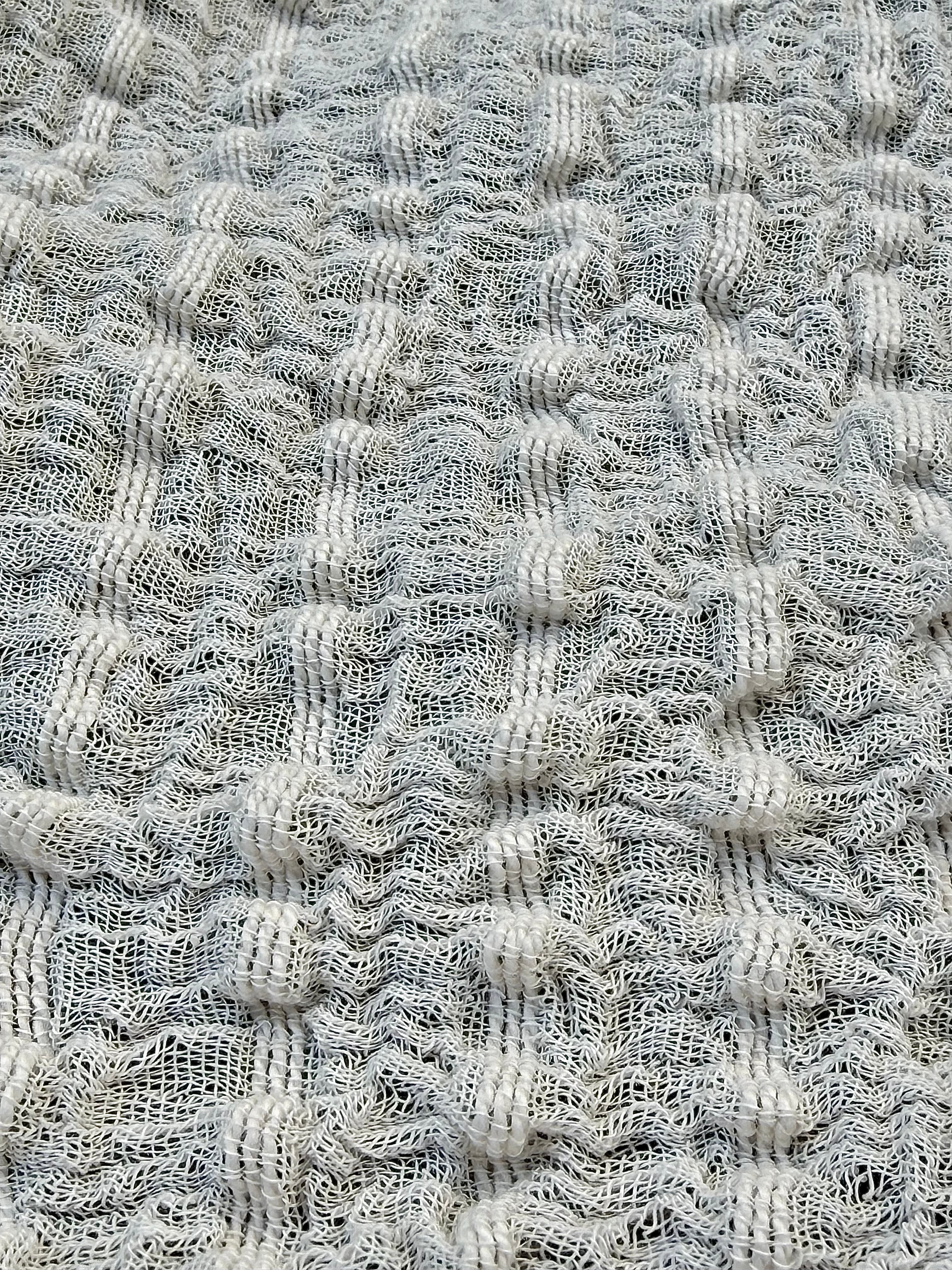 Tissu en coton froissé extensible neutre, surface texturée, coton tissé à la main blanc cassé, coton beige biologique semi-transparent et non blanchi.