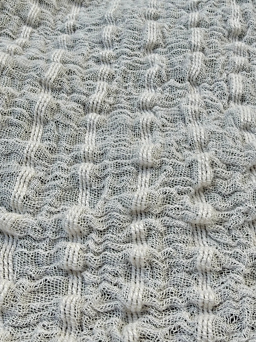 Tissu en coton froissé extensible neutre, surface texturée, coton tissé à la main blanc cassé, coton beige biologique semi-transparent et non blanchi.