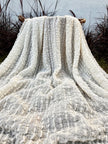 Tissu en coton froissé extensible neutre, surface texturée, coton tissé à la main blanc cassé, coton beige biologique semi-transparent et non blanchi.