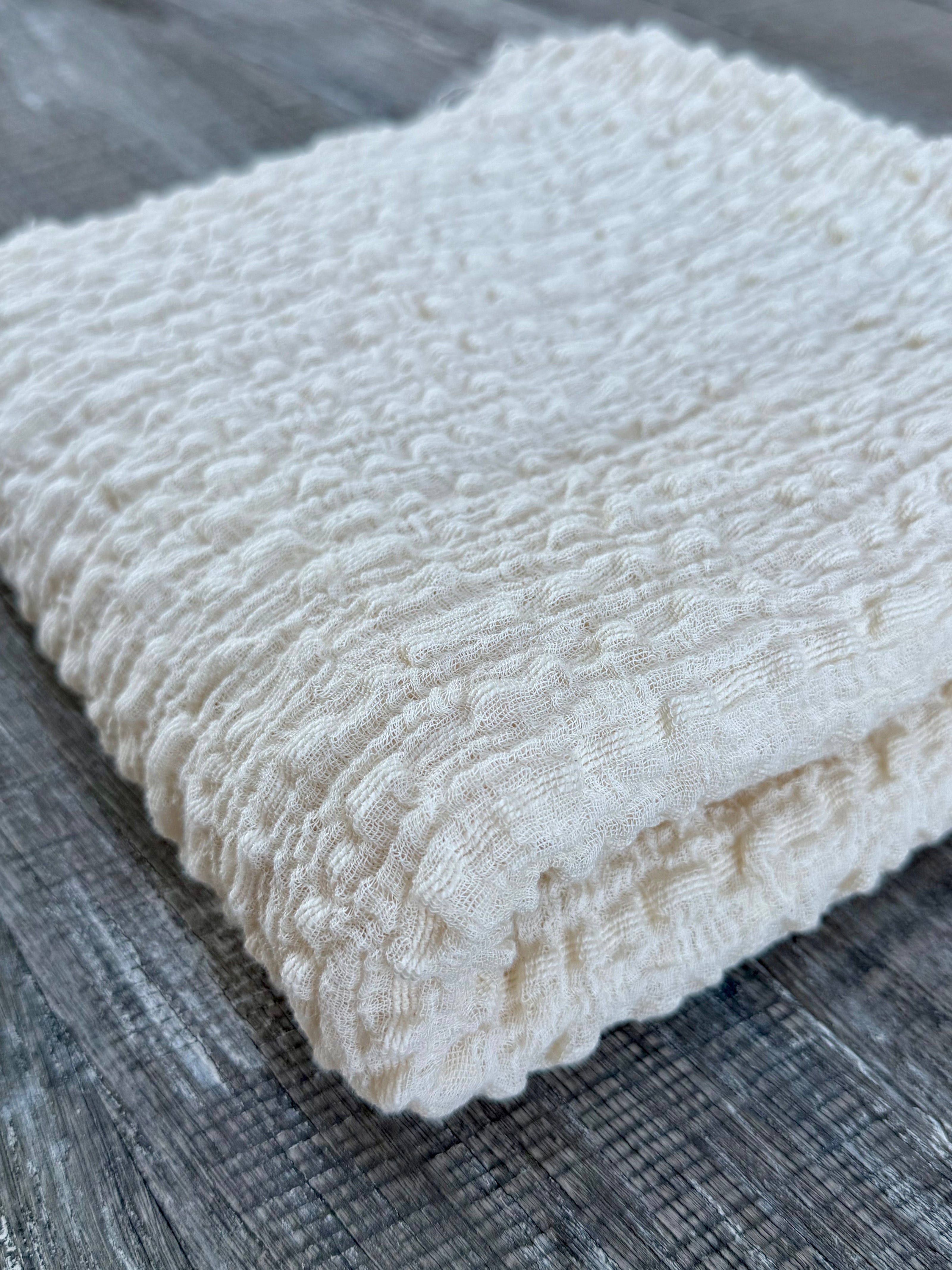 Tissu en coton froissé extensible neutre, surface texturée, coton tissé à la main blanc cassé, coton beige biologique semi-transparent et non blanchi.