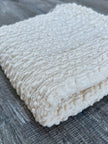 Tissu en coton froissé extensible neutre, surface texturée, coton tissé à la main blanc cassé, coton beige biologique semi-transparent et non blanchi.