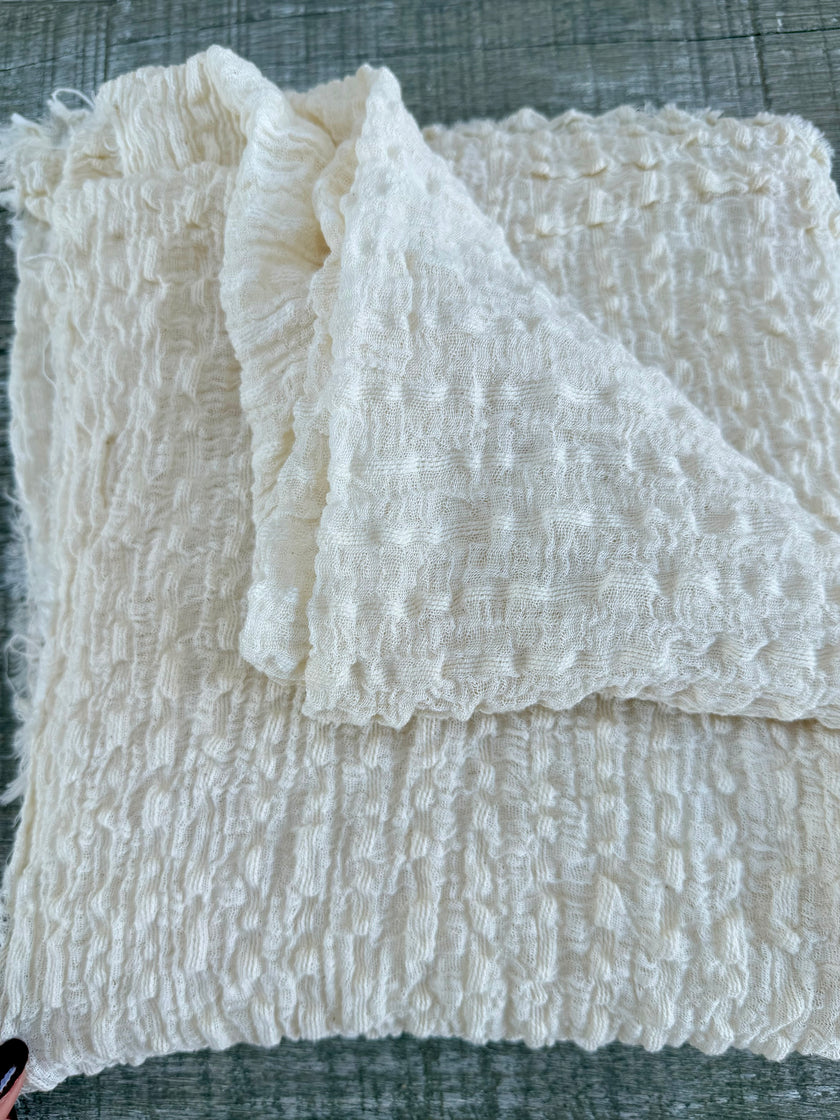 Tissu en coton froissé extensible neutre, surface texturée, coton tissé à la main blanc cassé, coton beige biologique semi-transparent et non blanchi.