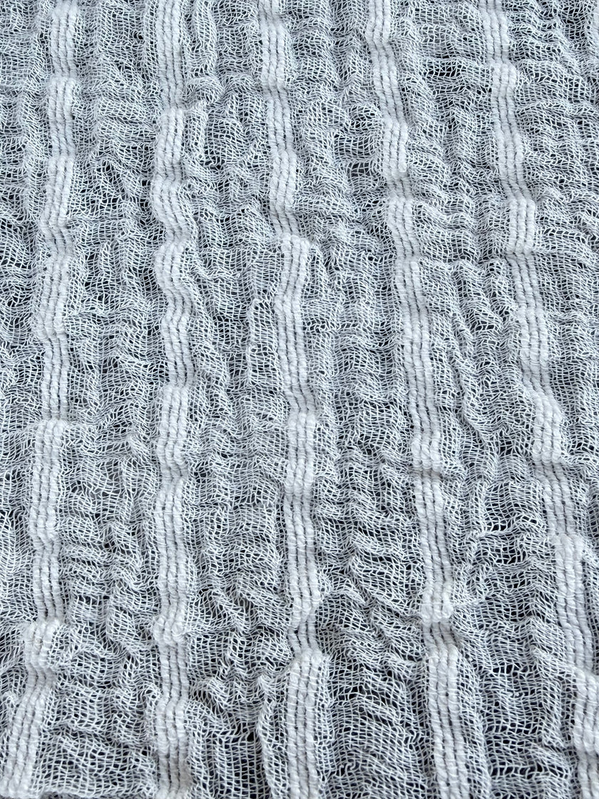 Tissu en coton froissé extensible neutre, surface texturée, coton tissé à la main blanc cassé, coton beige biologique semi-transparent et non blanchi.
