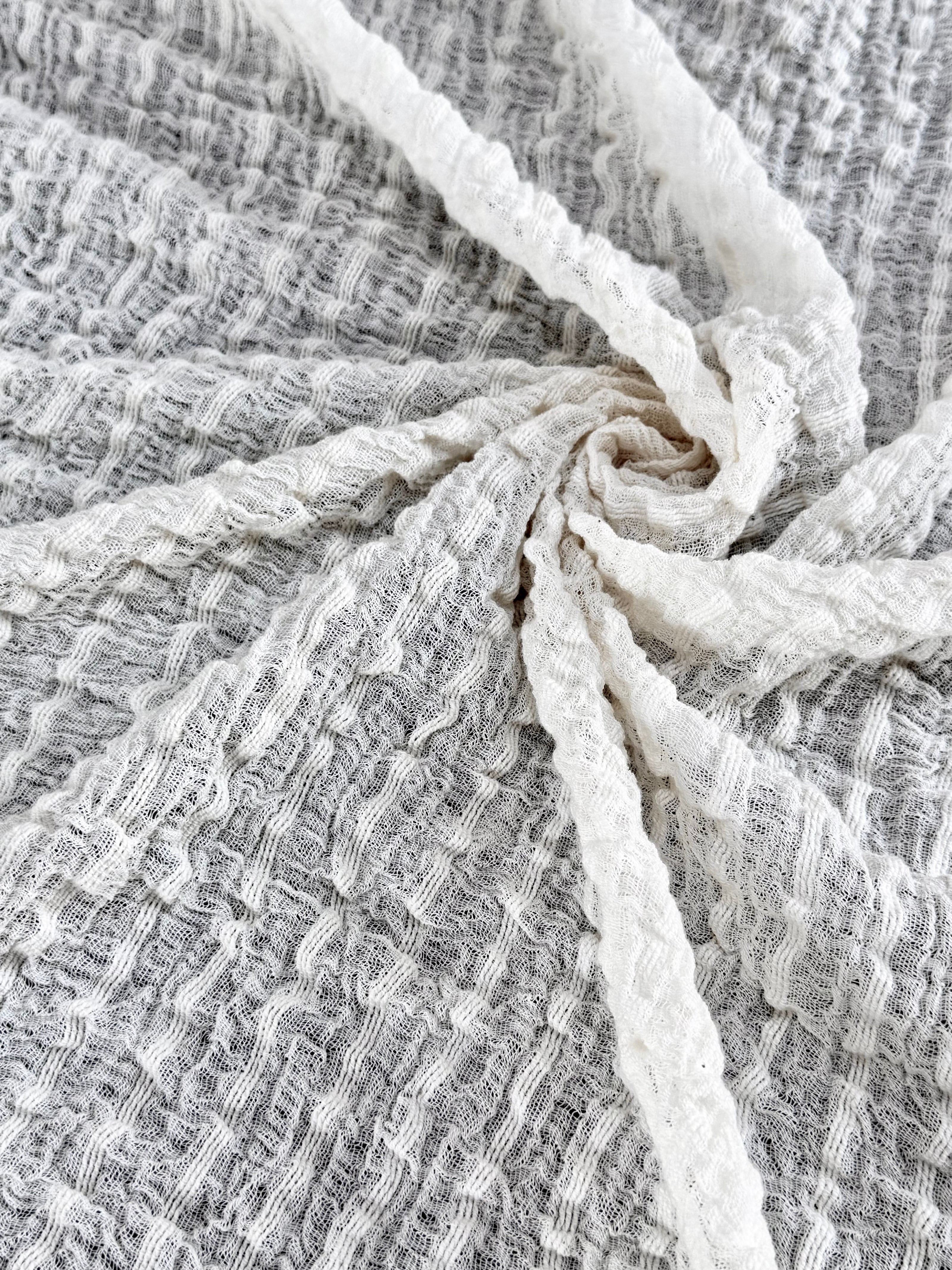 Tissu en coton froissé extensible neutre, surface texturée, coton tissé à la main blanc cassé, coton beige biologique semi-transparent et non blanchi.