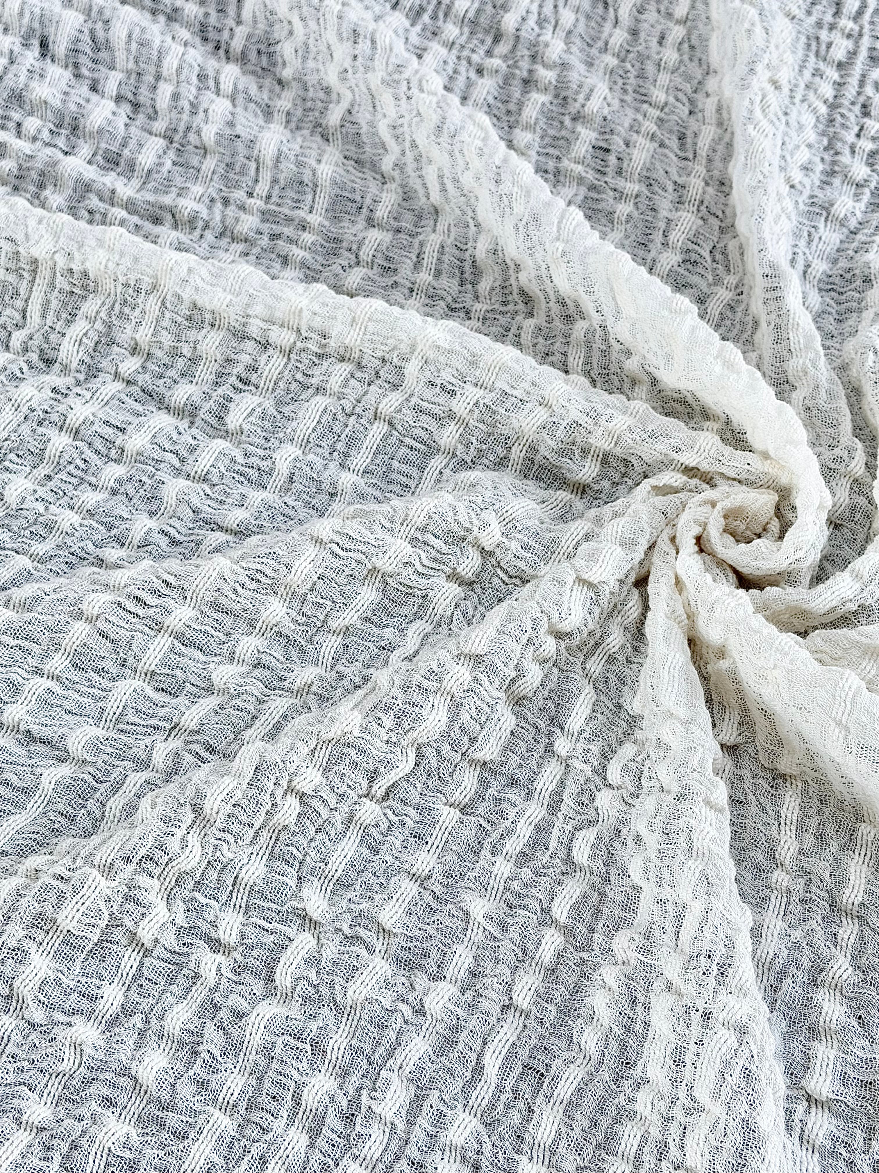 Tissu en coton froissé extensible neutre, surface texturée, coton tissé à la main blanc cassé, coton beige biologique semi-transparent et non blanchi.