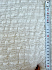 Tissu en coton froissé extensible neutre, surface texturée, coton tissé à la main blanc cassé, coton beige biologique semi-transparent et non blanchi.