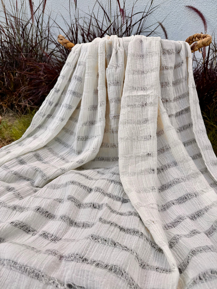 Tissu en coton froissé extensible neutre, surface texturée, coton tissé à la main blanc cassé, coton beige biologique semi-transparent et non blanchi.