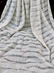 Tissu en coton froissé extensible neutre, surface texturée, coton tissé à la main blanc cassé, coton beige biologique semi-transparent et non blanchi.