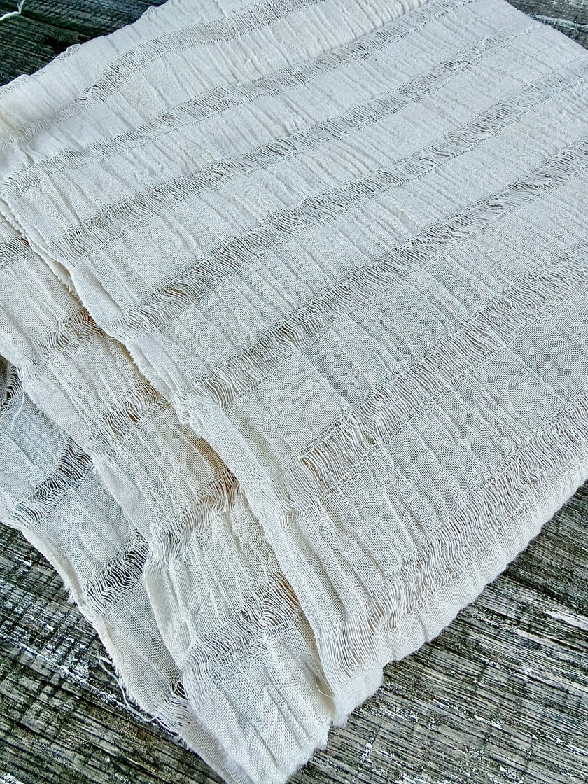 Tissu en coton froissé extensible neutre, surface texturée, coton tissé à la main blanc cassé, coton beige biologique semi-transparent et non blanchi.