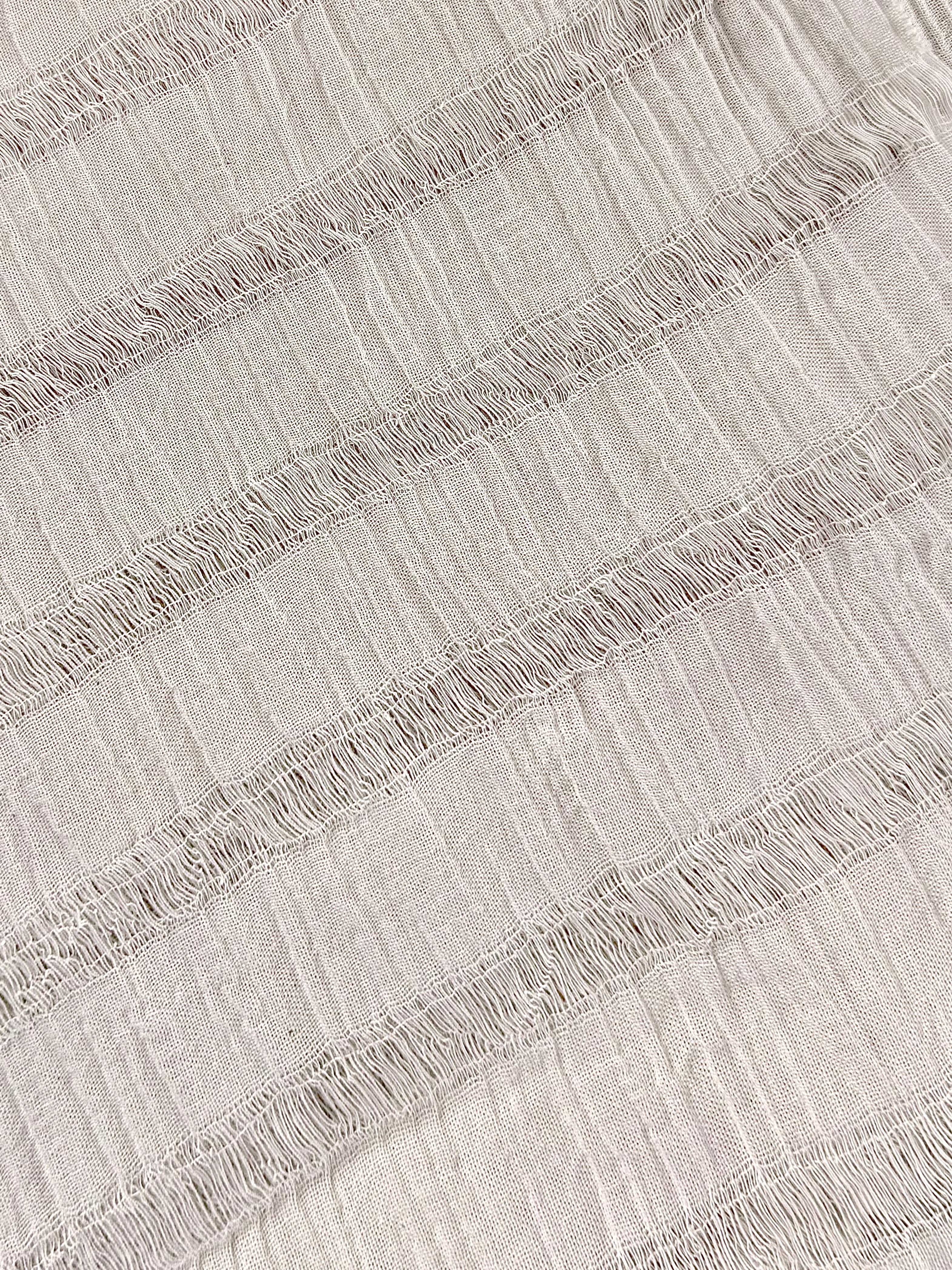 Tissu en coton froissé extensible neutre, surface texturée, coton tissé à la main blanc cassé, coton beige biologique semi-transparent et non blanchi.