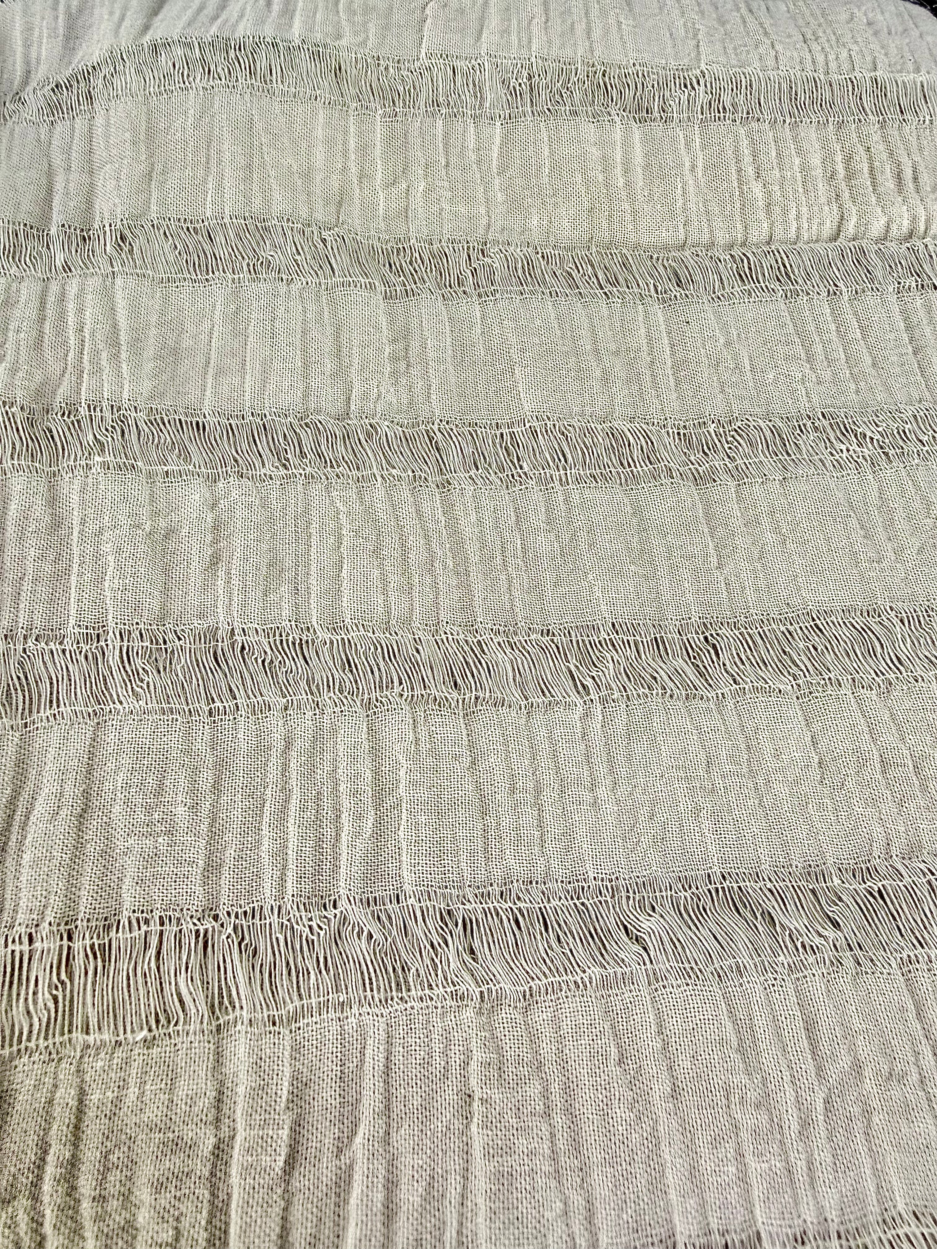 Tissu en coton froissé extensible neutre, surface texturée, coton tissé à la main blanc cassé, coton beige biologique semi-transparent et non blanchi.