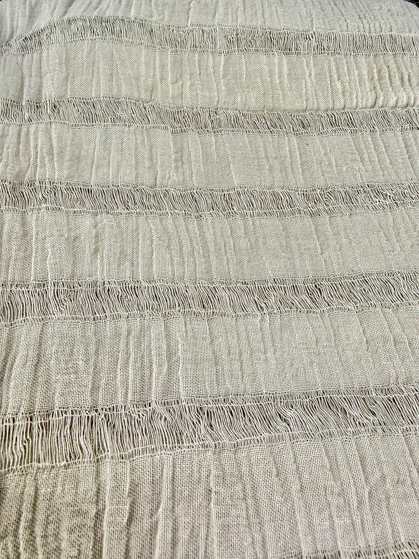Tissu en coton froissé extensible neutre, surface texturée, coton tissé à la main blanc cassé, coton beige biologique semi-transparent et non blanchi.