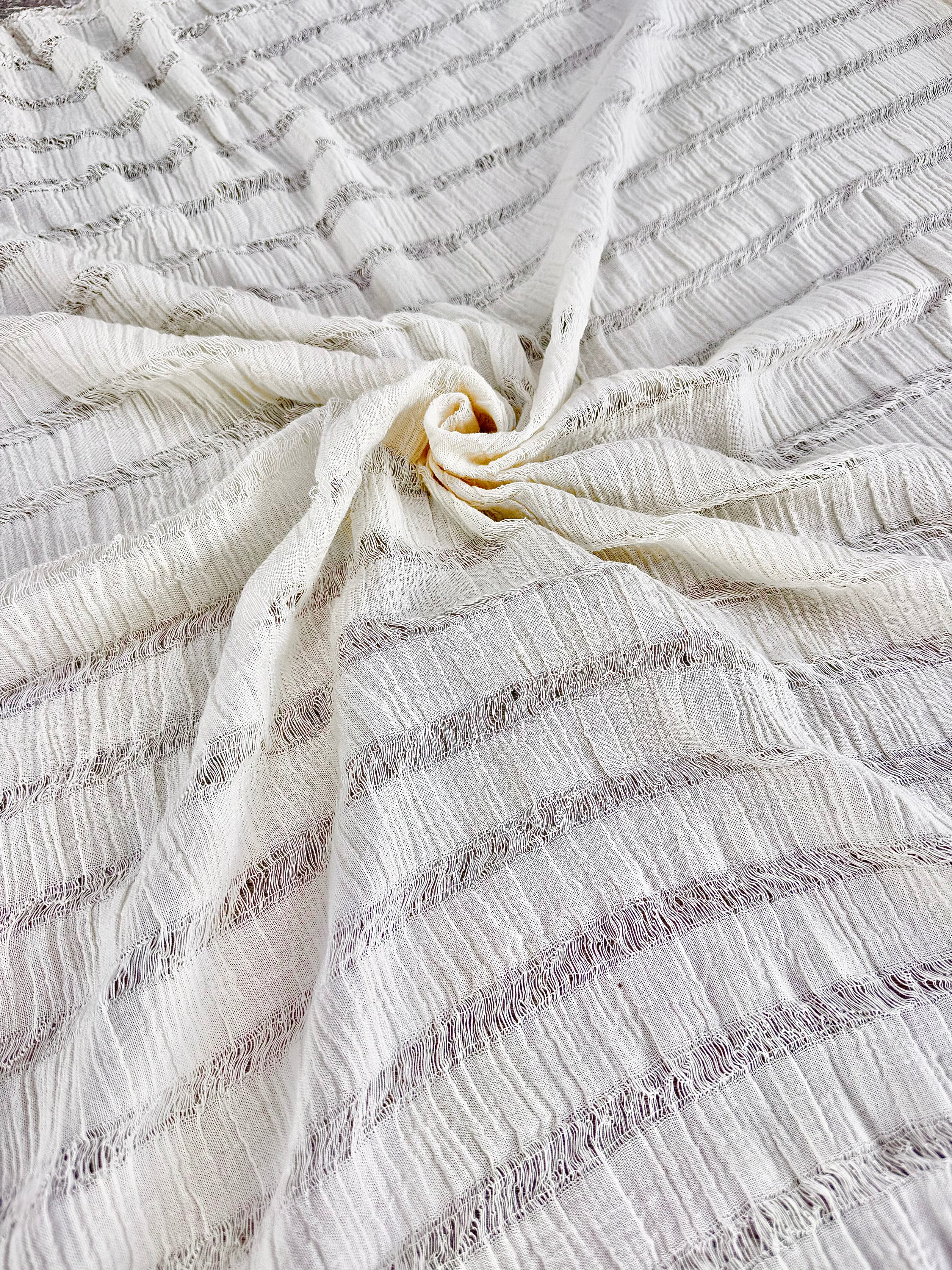 Tissu en coton froissé extensible neutre, surface texturée, coton tissé à la main blanc cassé, coton beige biologique semi-transparent et non blanchi.