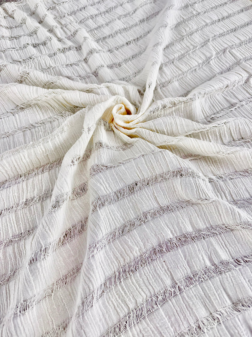 Tissu en coton froissé extensible neutre, surface texturée, coton tissé à la main blanc cassé, coton beige biologique semi-transparent et non blanchi.