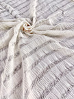 Tissu en coton froissé extensible neutre, surface texturée, coton tissé à la main blanc cassé, coton beige biologique semi-transparent et non blanchi.