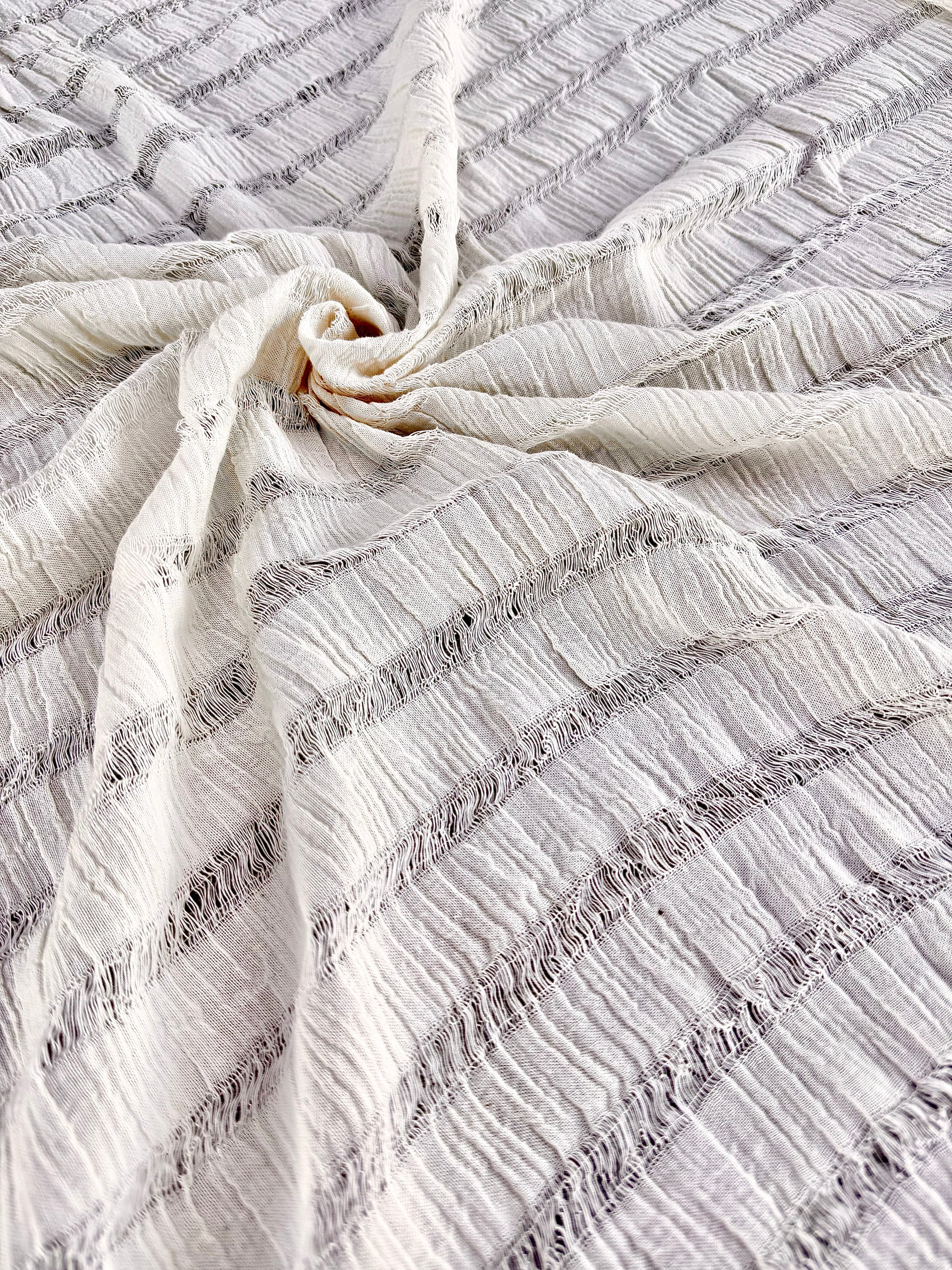 Tissu en coton froissé extensible neutre, surface texturée, coton tissé à la main blanc cassé, coton beige biologique semi-transparent et non blanchi.