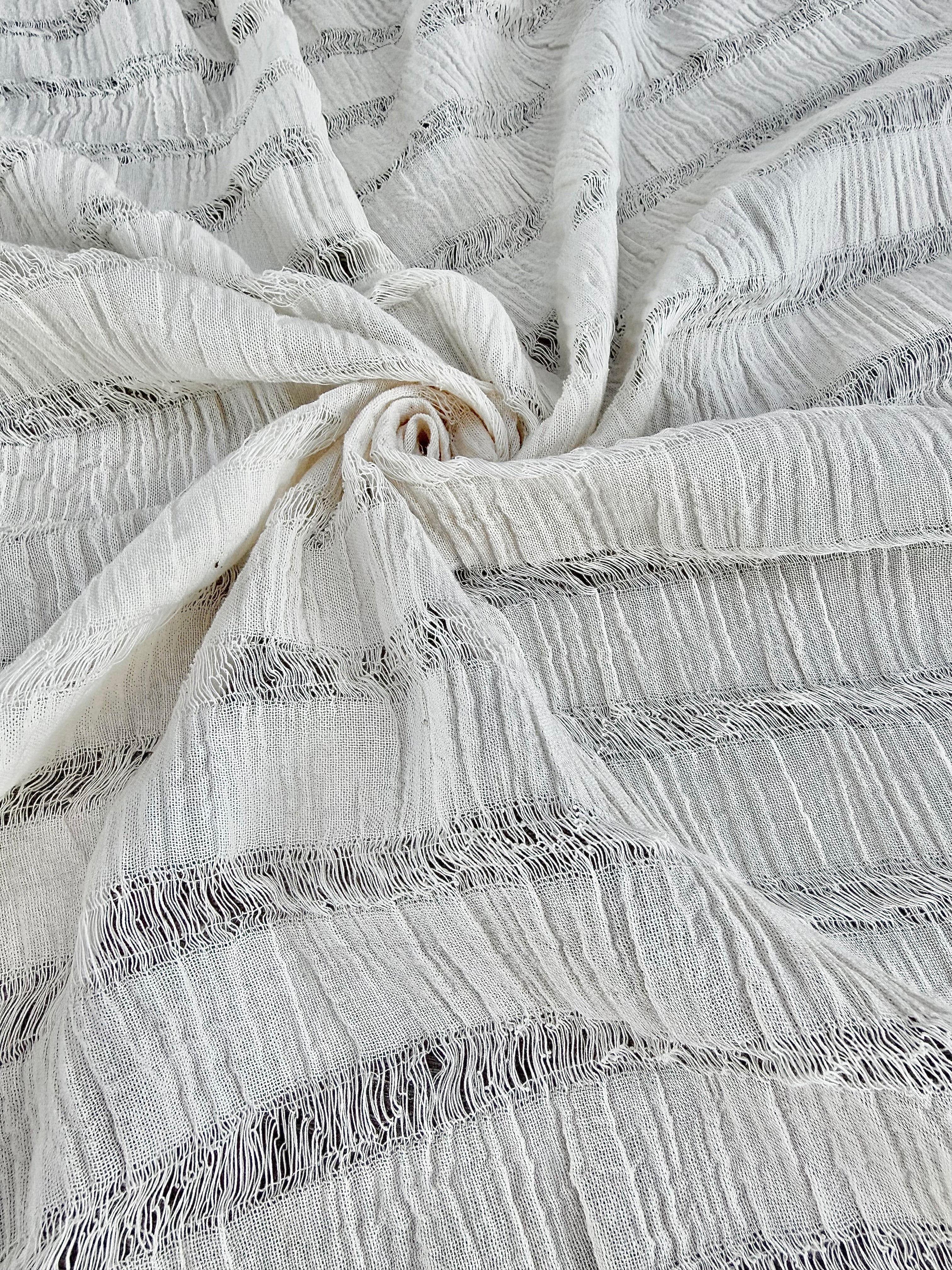 Tissu en coton froissé extensible neutre, surface texturée, coton tissé à la main blanc cassé, coton beige biologique semi-transparent et non blanchi.