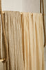 Tissu en coton froissé extensible neutre, surface texturée, coton tissé à la main blanc cassé, coton beige biologique semi-transparent et non blanchi.